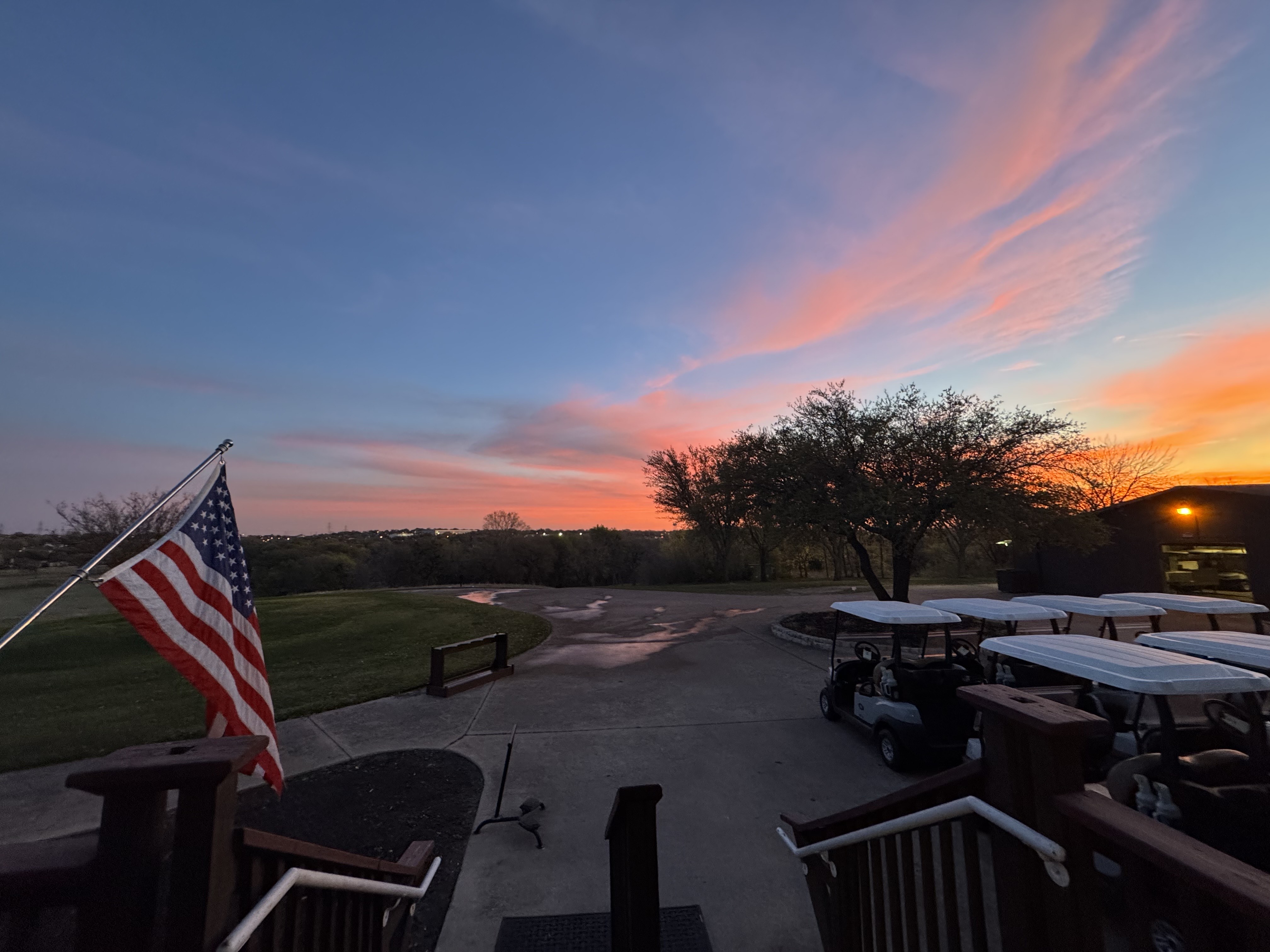 Golf carts park during sunset 